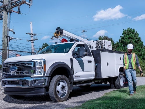2024 Ford Chassis Cab upfitted as a electrical work truck parked next to a powerline