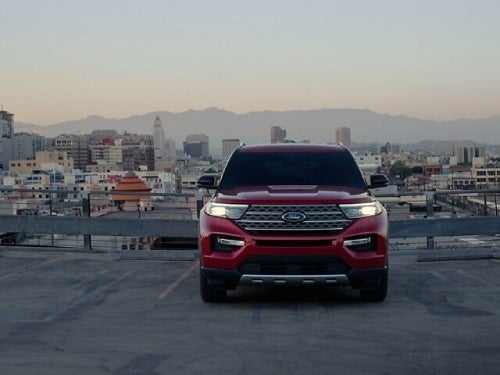 2024 Ford Explorer front exterior view of car parked outside a city at dusk with headlights on