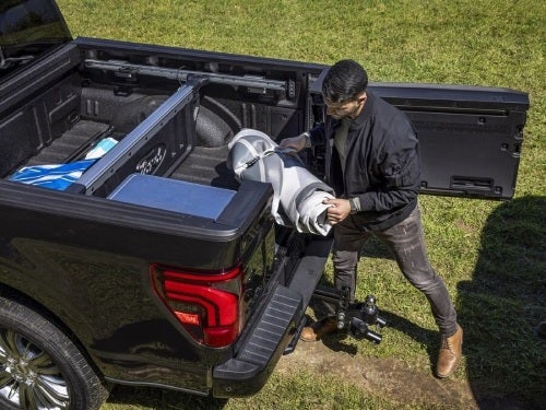 2024 Ford F-150 view of man using proaccess tailgate to load something into the bed of the truck